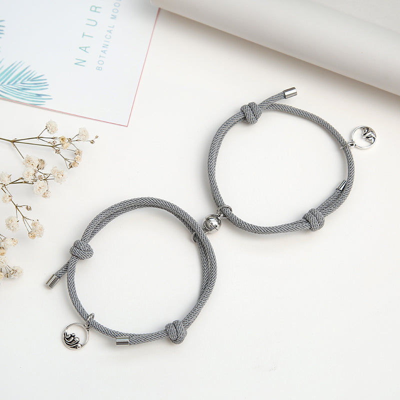 A pair of stylish alloy couple bracelets featuring magnetic attraction balls, symbolizing love and connection.