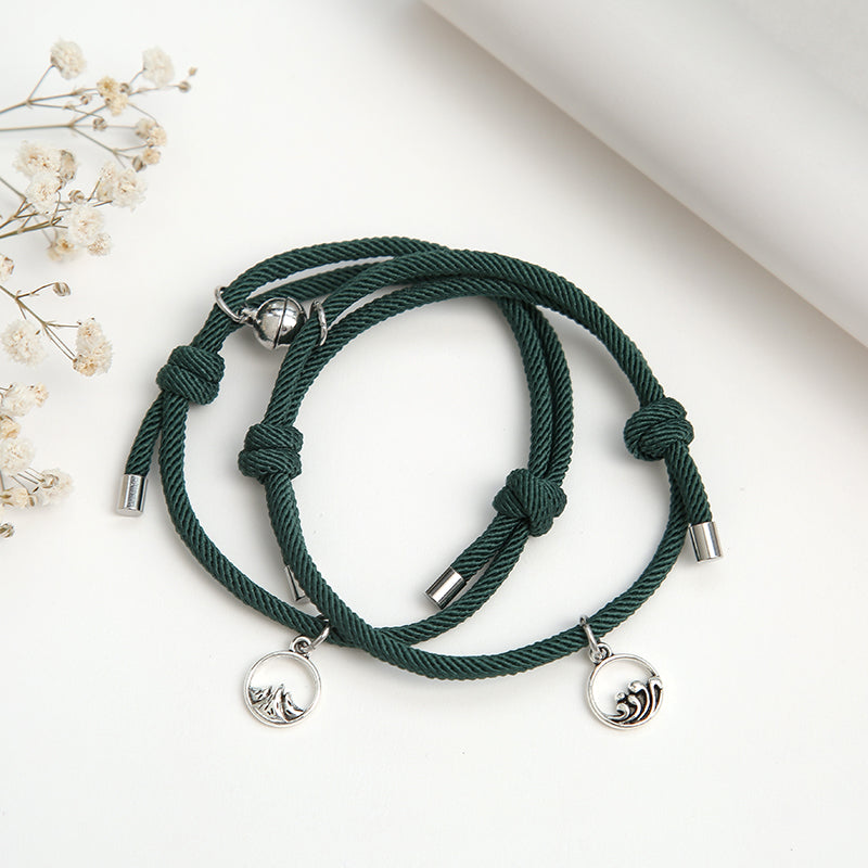 A pair of stylish alloy couple bracelets featuring magnetic attraction balls, symbolizing love and connection.