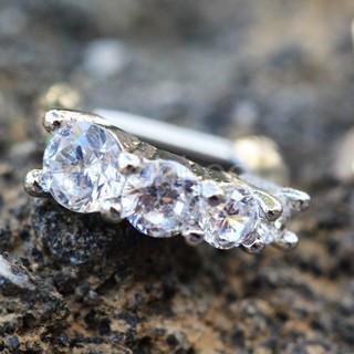 A close-up of a 316L stainless steel cartilage clicker earring featuring cascading cubic zirconia stones in various sizes, showcasing its elegant design.