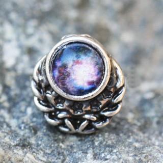 A 316L stainless steel cartilage earring featuring a vibrant galaxy charm design with blue and red resin, chains, and stars.