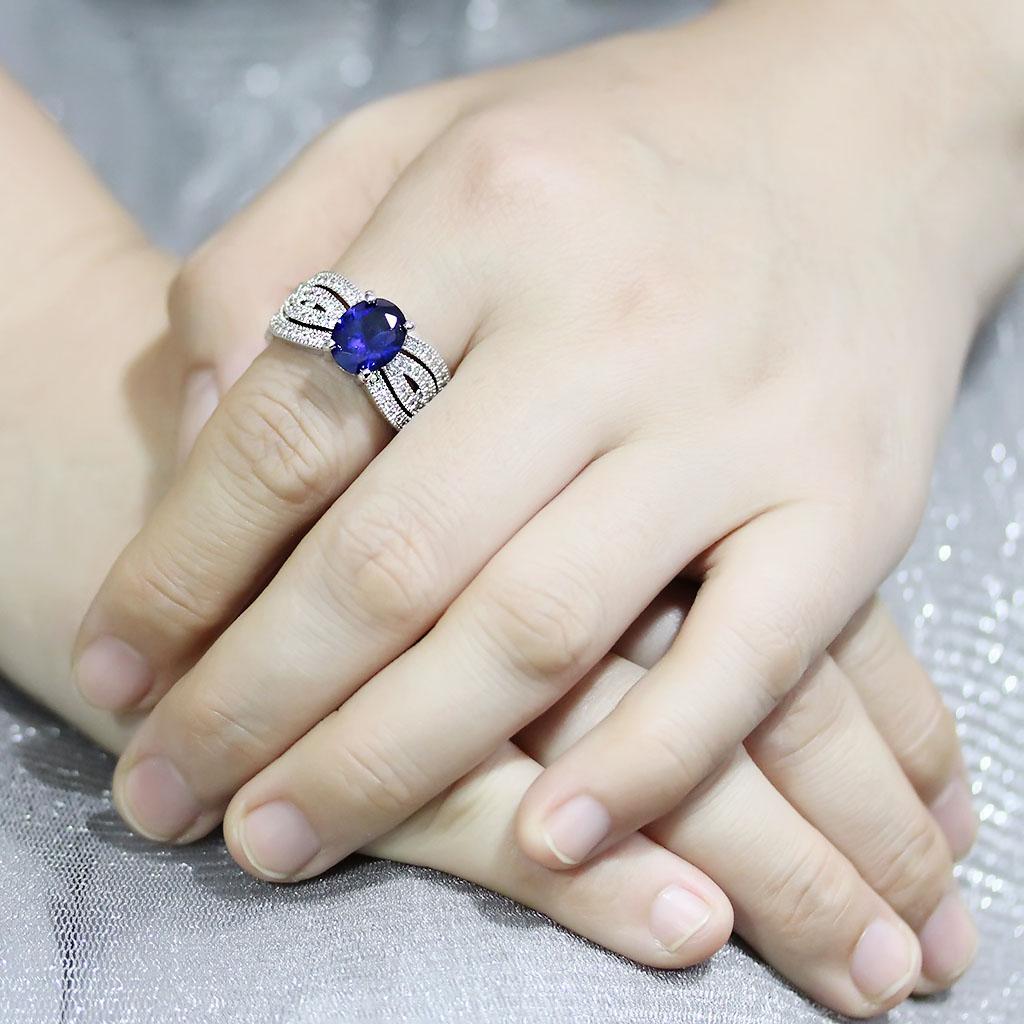 Rhodium brass ring featuring a synthetic London Blue spinel, showcasing its elegant design and vibrant color.