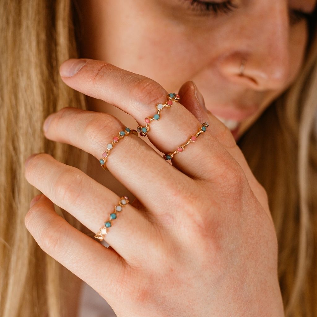 A set of four gold stackable rings featuring intricate tribal designs and vibrant multi-coloured stones, perfect for bohemian style.