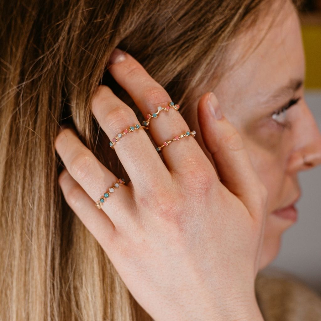 A set of four gold stackable rings featuring intricate tribal designs and vibrant multi-coloured stones, perfect for bohemian style.