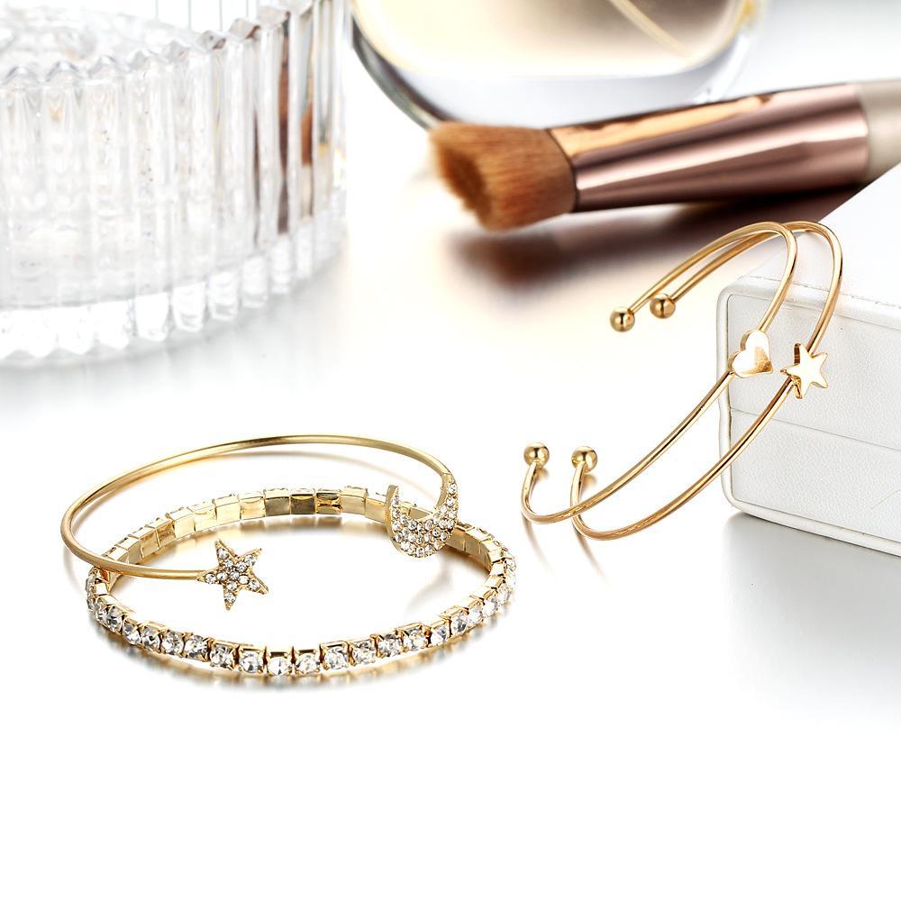 A luxurious 4 Piece Celestial Bangle Set featuring sparkling crystals and 18K gold plating, elegantly displayed on a soft surface.