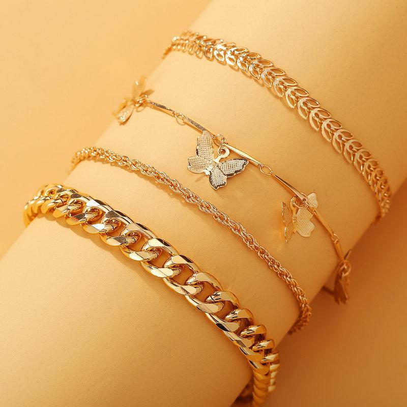 A luxurious 4 Piece Chain and Butterfly Bracelet Set, featuring intricate designs in 18K gold plating, showcasing elegance and style.