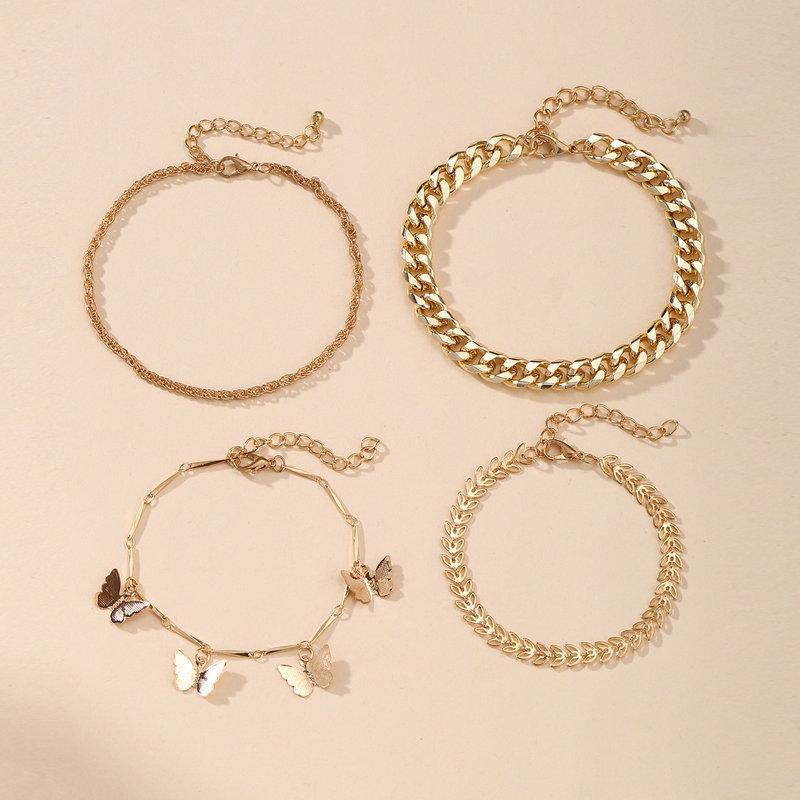 A luxurious 4 Piece Chain and Butterfly Bracelet Set, featuring intricate designs in 18K gold plating, showcasing elegance and style.