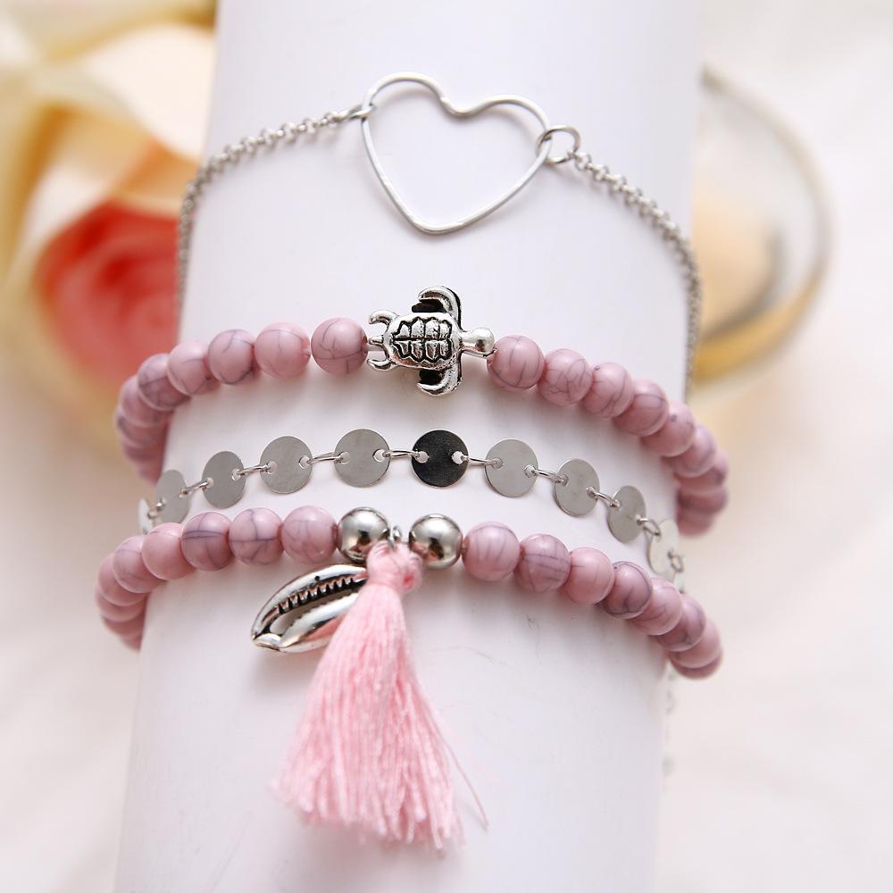 4 Piece Pink Tassel Bracelet Set featuring 18K white gold plating, showcasing elegant pink tassels and a comfortable fit.