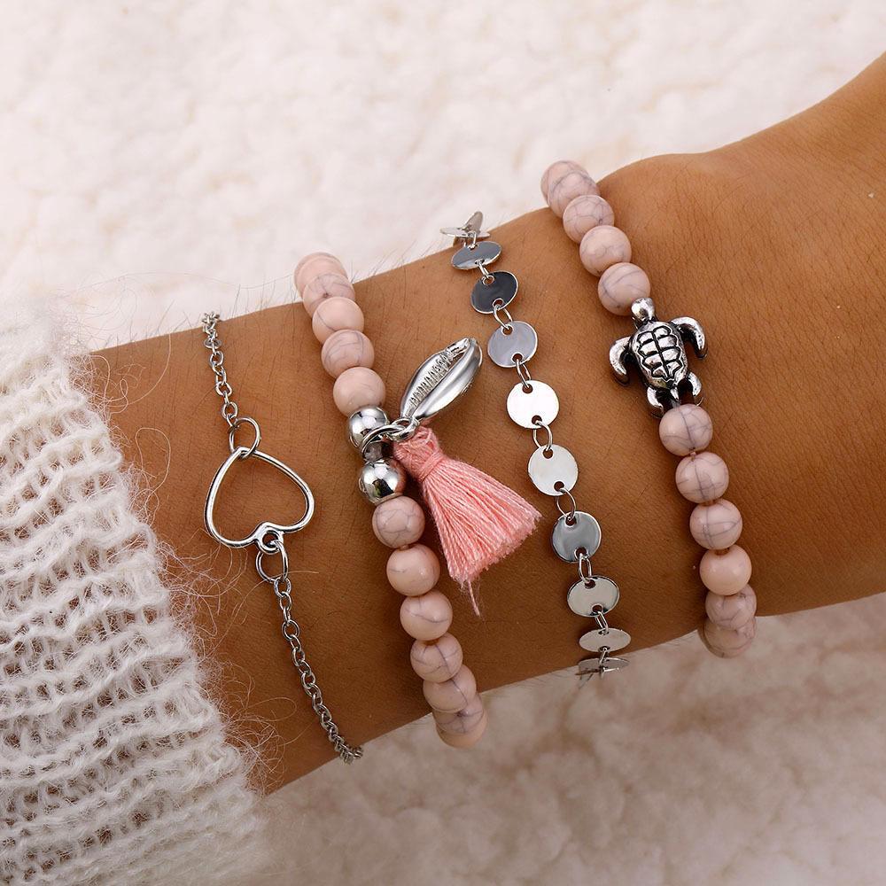 4 Piece Pink Tassel Bracelet Set featuring 18K white gold plating, showcasing elegant pink tassels and a comfortable fit.
