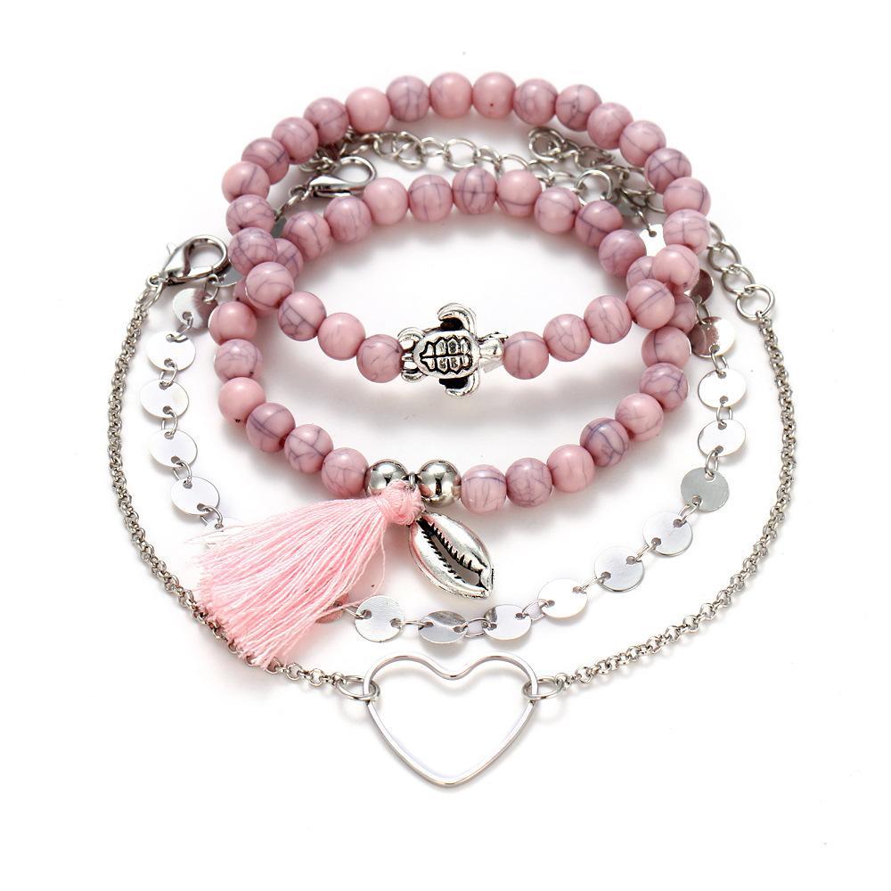4 Piece Pink Tassel Bracelet Set featuring 18K white gold plating, showcasing elegant pink tassels and a comfortable fit.