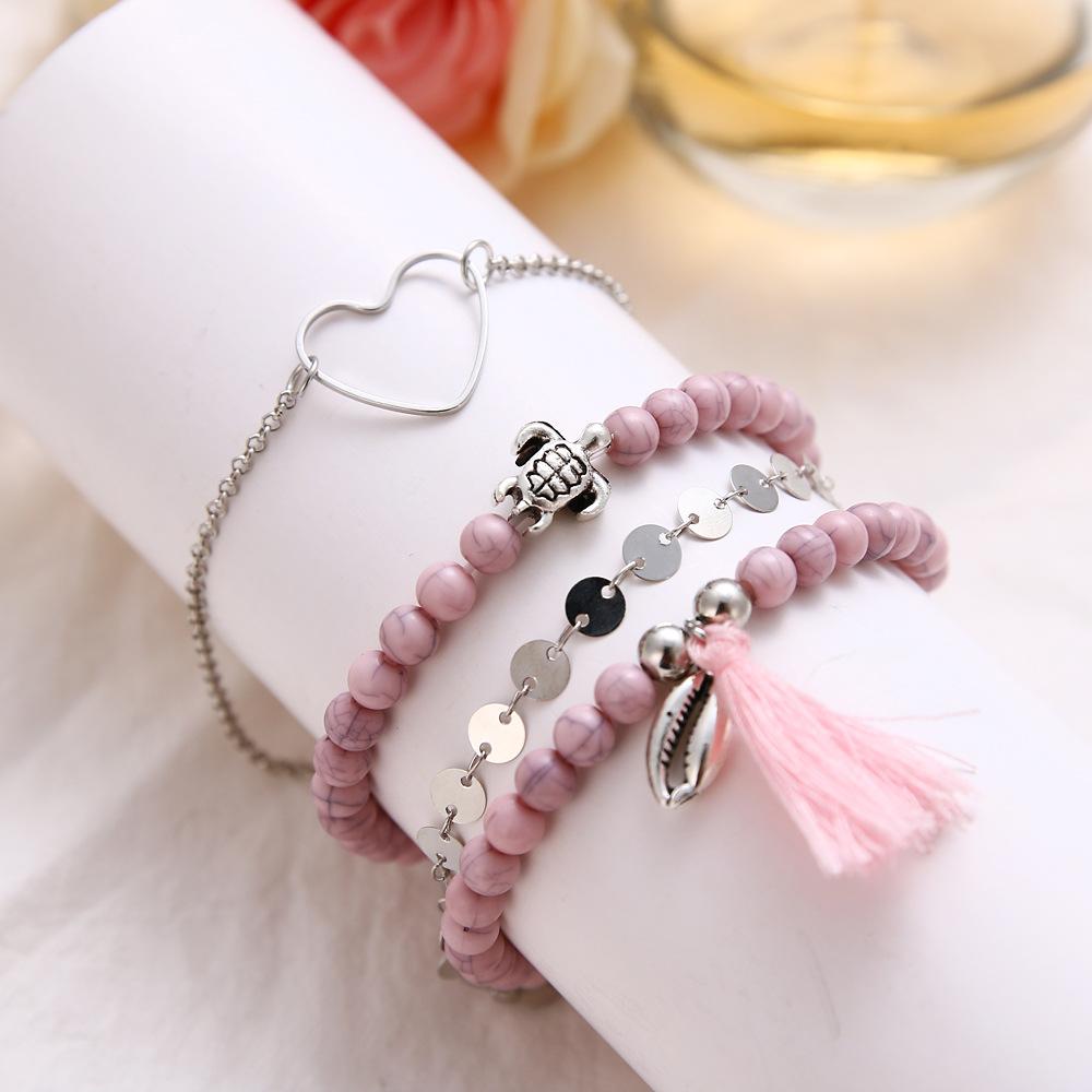 4 Piece Pink Tassel Bracelet Set featuring 18K white gold plating, showcasing elegant pink tassels and a comfortable fit.