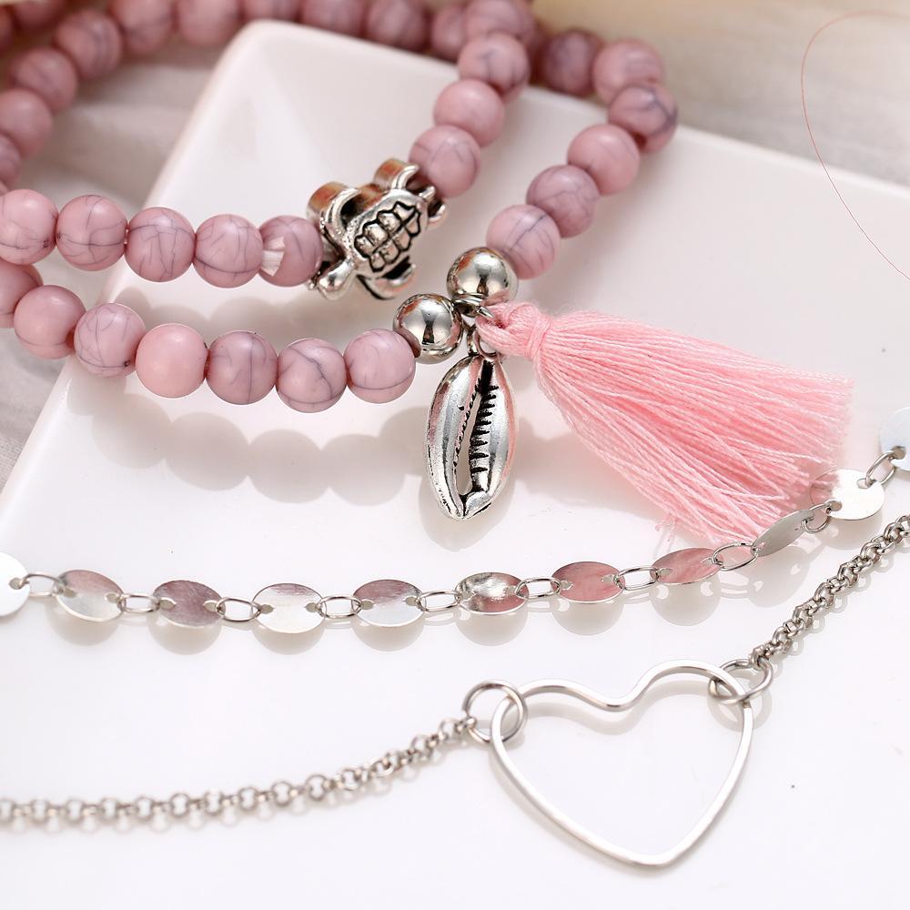 4 Piece Pink Tassel Bracelet Set featuring 18K white gold plating, showcasing elegant pink tassels and a comfortable fit.