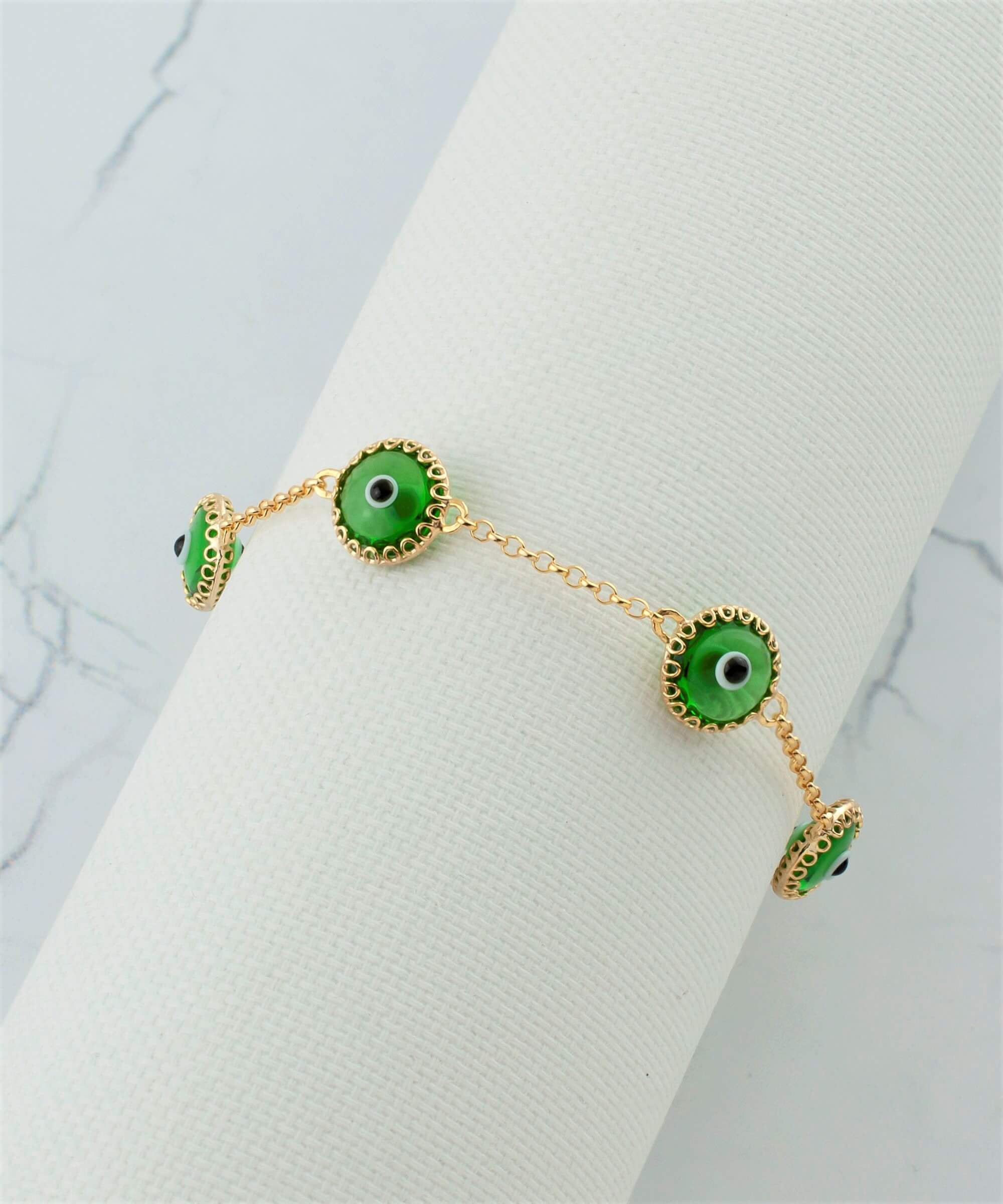 Mint green evil eye bracelet featuring five beads on a gold plated sterling silver link chain, secured with a lobster claw clasp.
