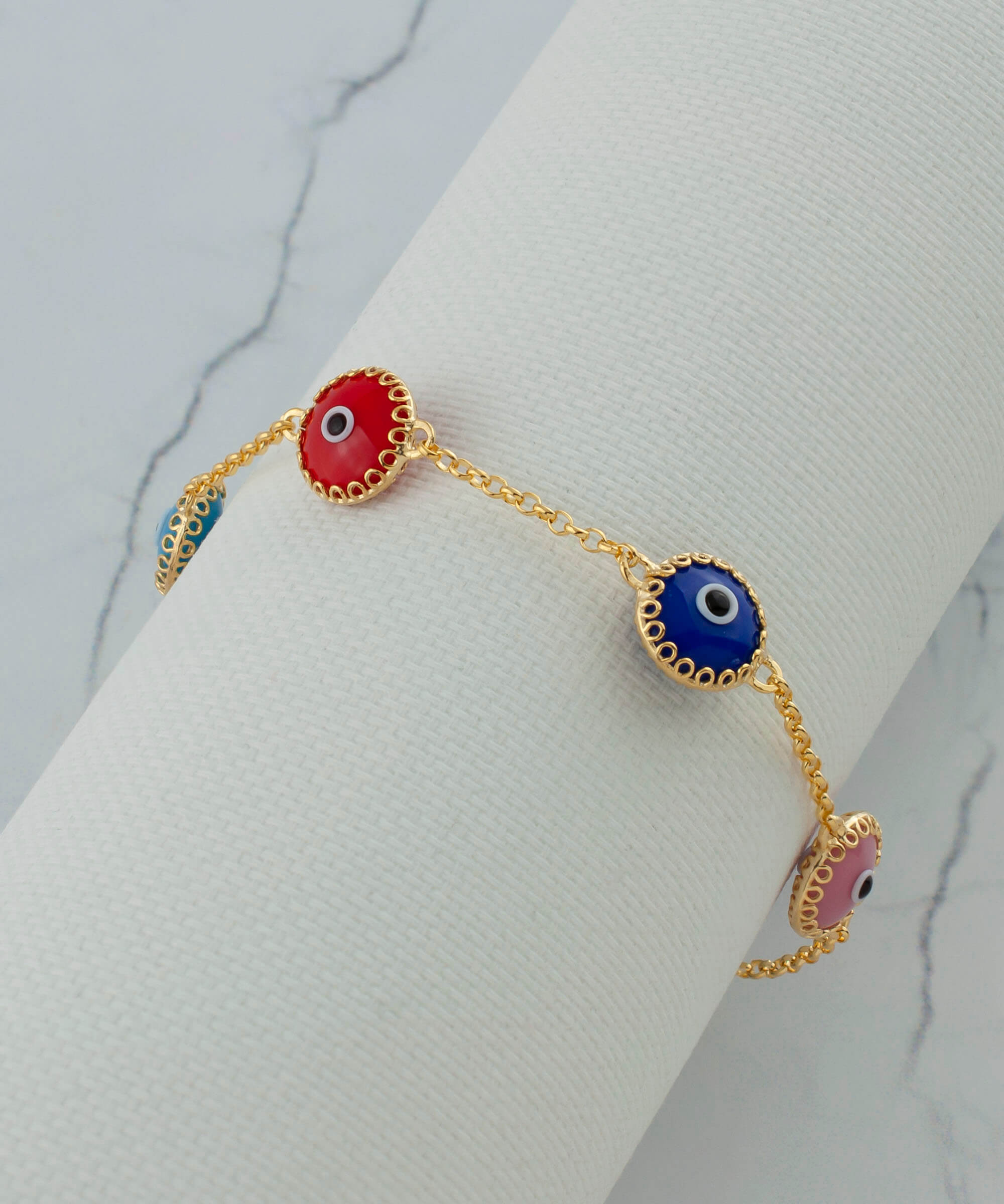 A stylish gold plated sterling silver link bracelet featuring five colorful evil eye beads, designed for women.