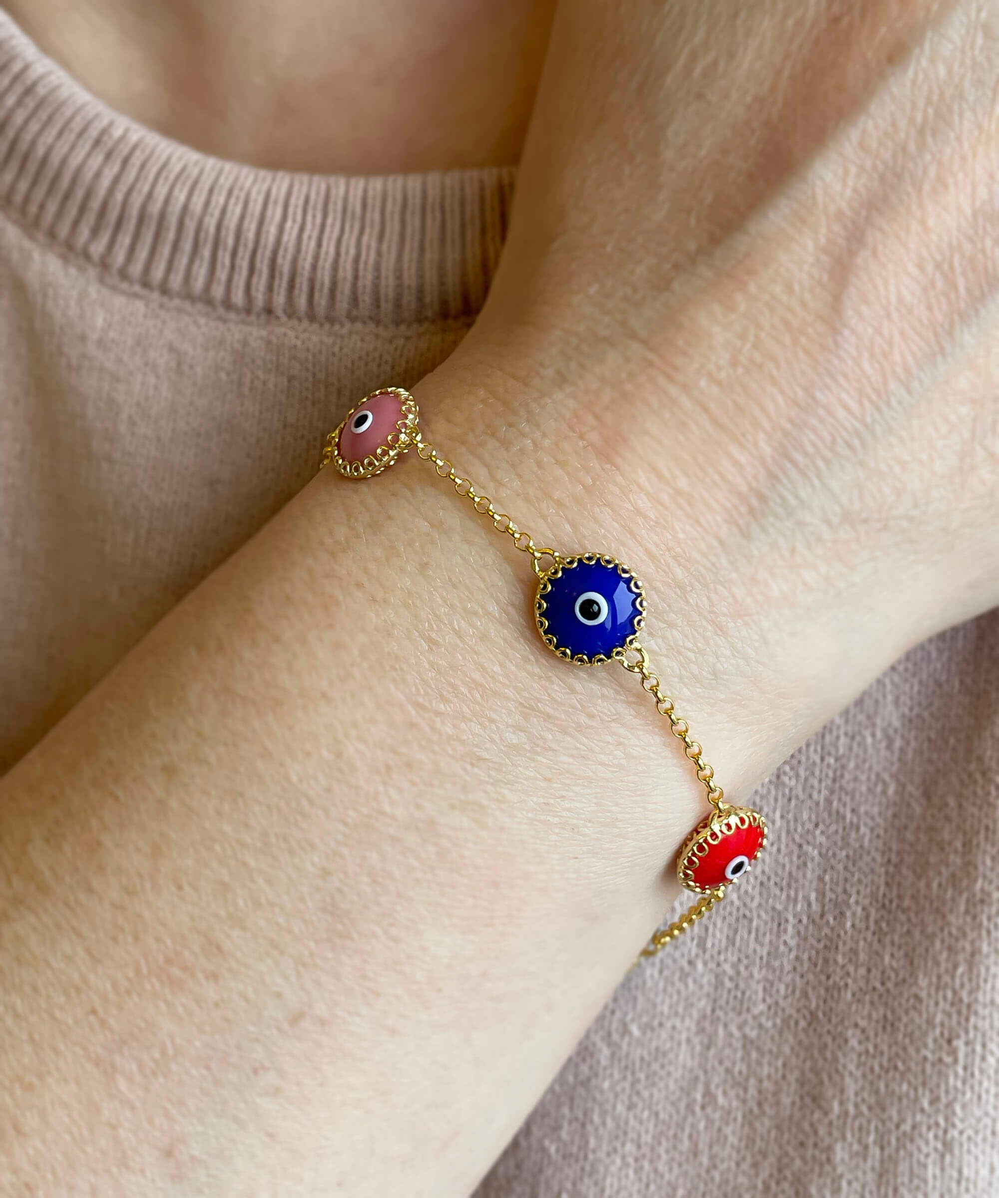 A stylish gold plated sterling silver link bracelet featuring five colorful evil eye beads, designed for women.