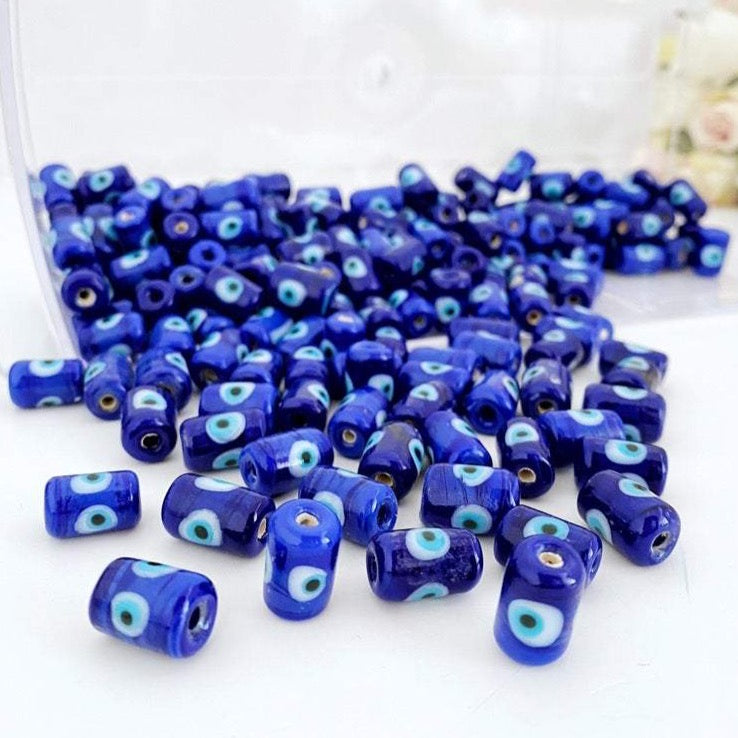 Five blue evil eye tube beads made of Murano glass, showcasing intricate designs and vibrant colors, ideal for jewelry making.