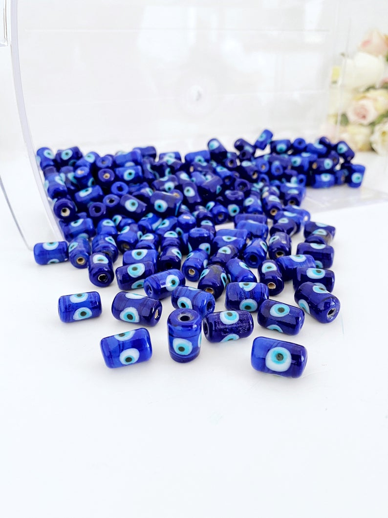 Five blue evil eye tube beads made of Murano glass, showcasing intricate designs and vibrant colors, ideal for jewelry making.
