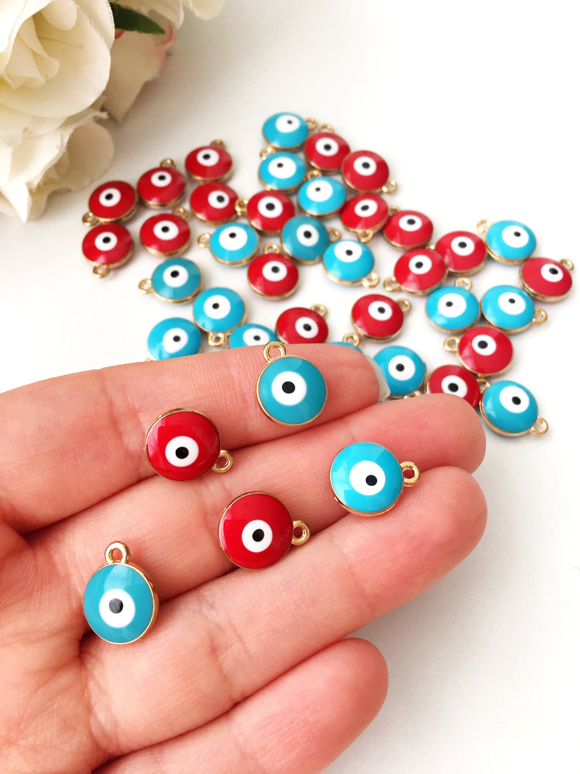 Five gold plated evil eye charms featuring turquoise and red designs, perfect for necklace crafting.