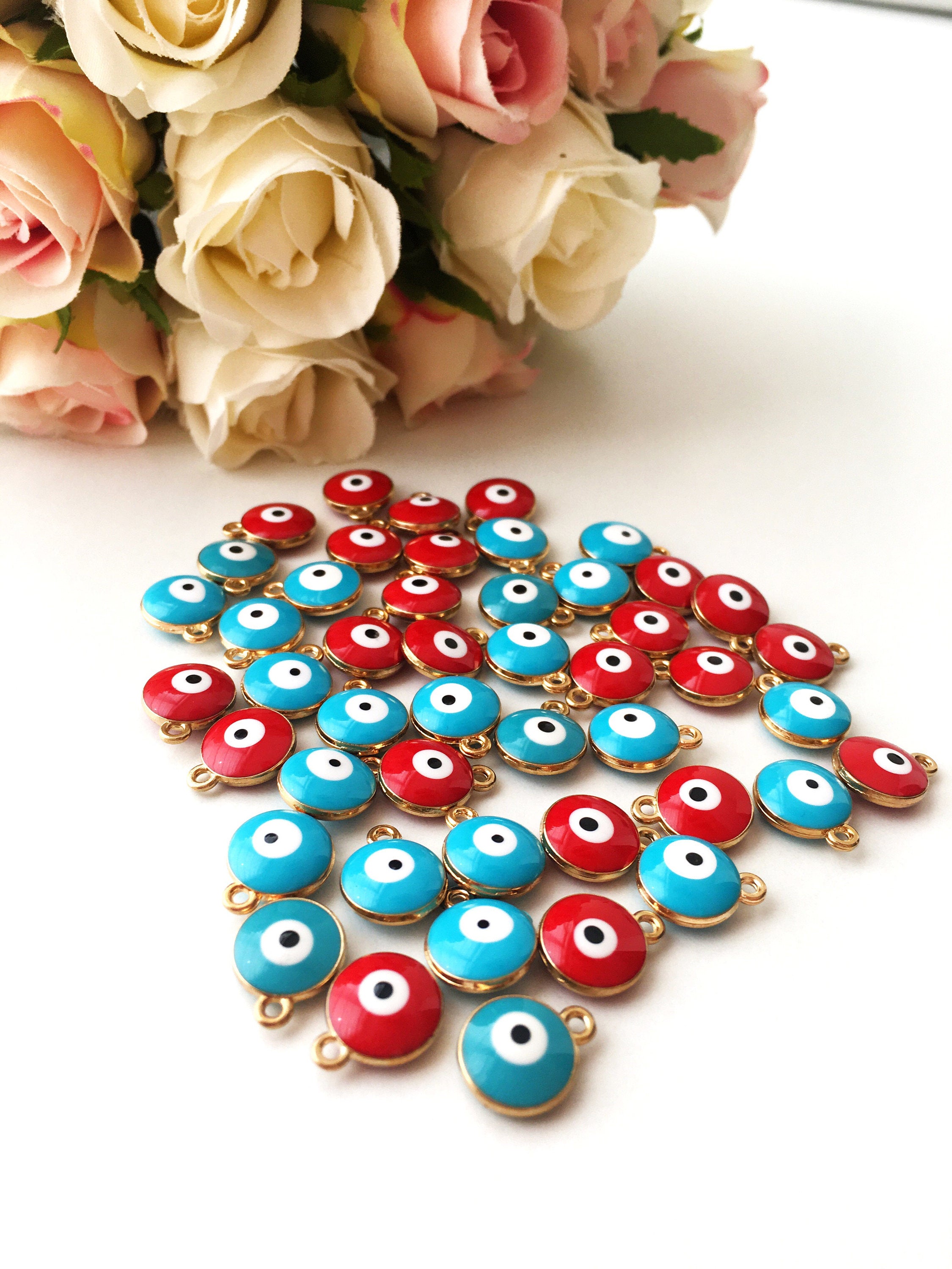 Five gold plated evil eye charms featuring turquoise and red designs, perfect for necklace crafting.