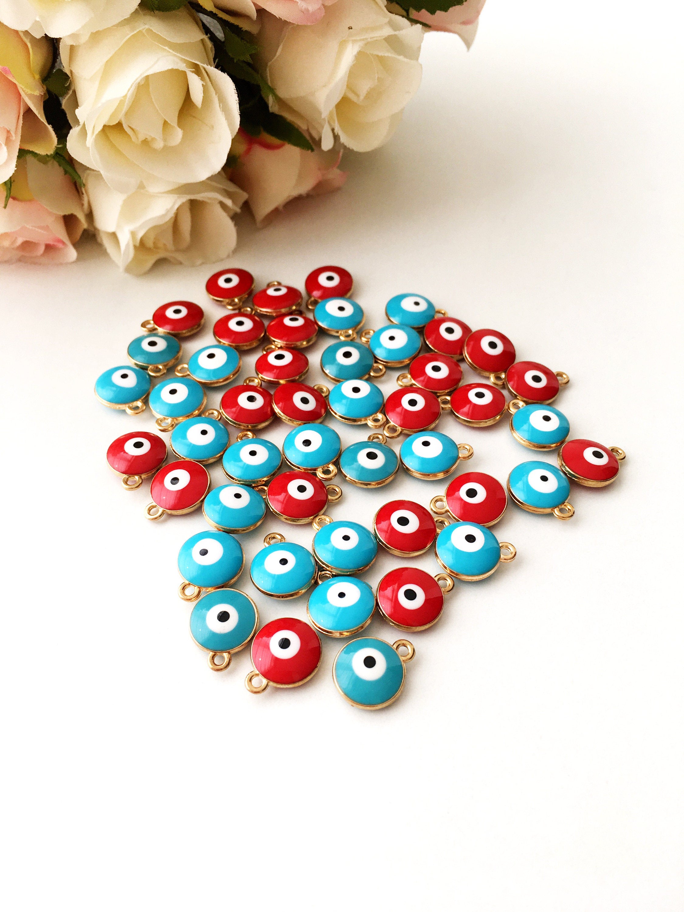 Five gold plated evil eye charms featuring turquoise and red designs, perfect for necklace crafting.
