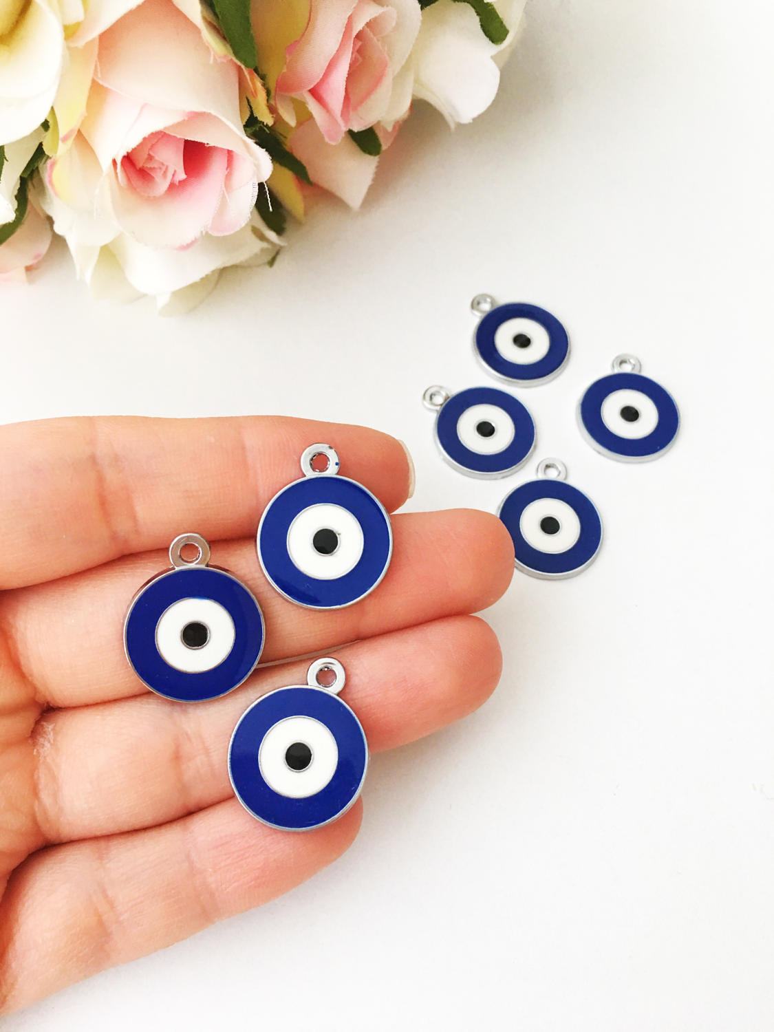 Five 20mm brass evil eye charms with blue enamel design, ideal for jewelry making.