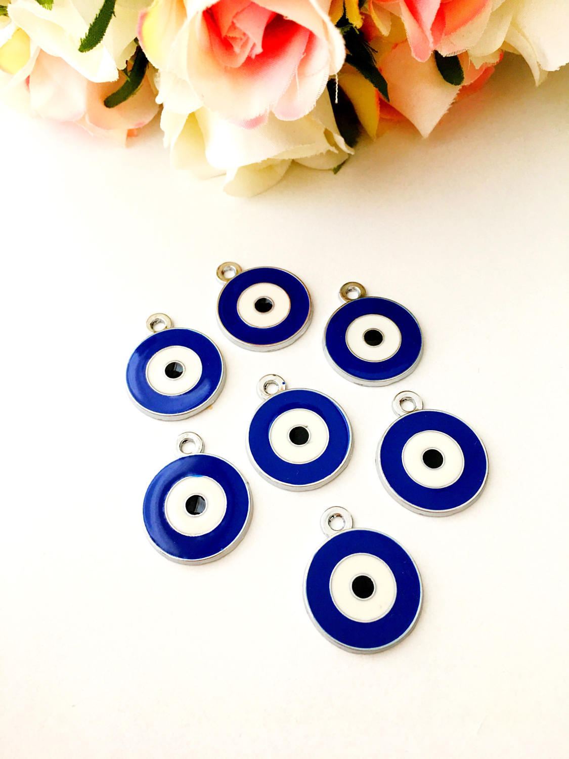 Five 20mm brass evil eye charms with blue enamel design, ideal for jewelry making.