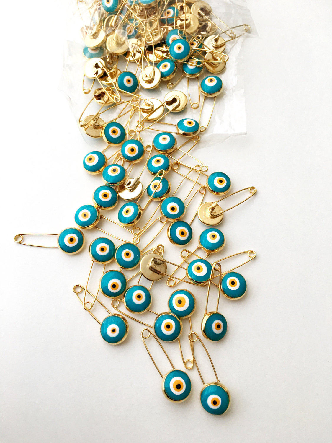 Set of 5 green evil eye safety pins with gold plating, featuring big enamel evil eye charms for baby protection.
