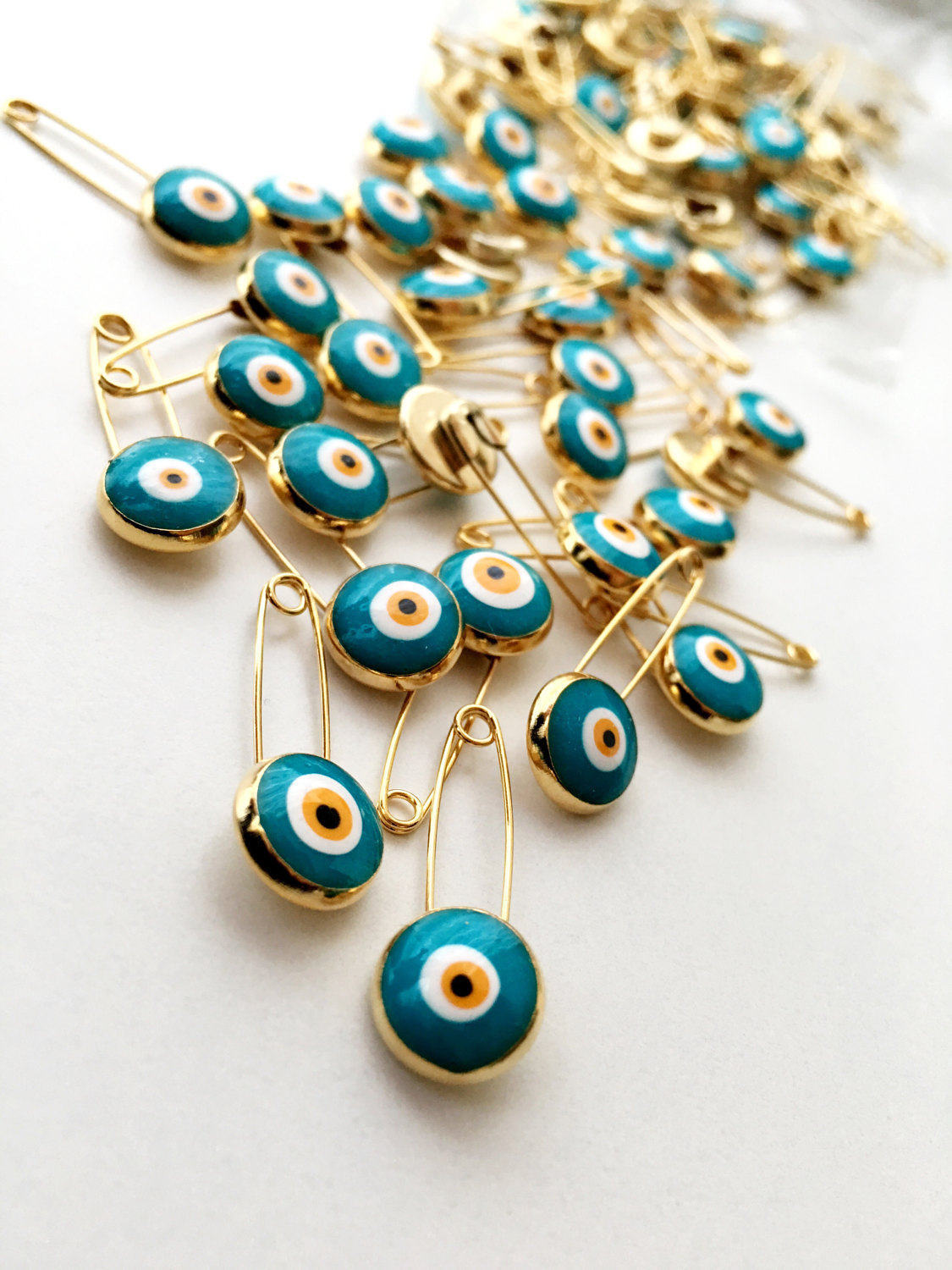 Set of 5 green evil eye safety pins with gold plating, featuring big enamel evil eye charms for baby protection.