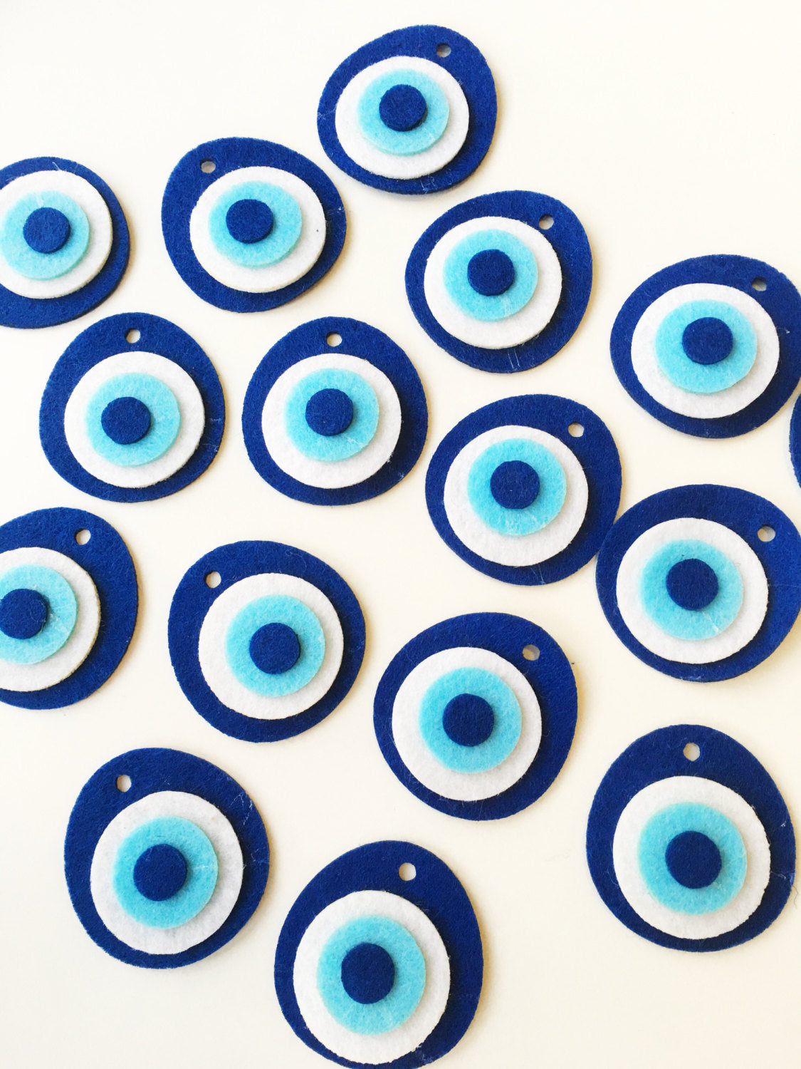 Five handmade felted evil eye beads, each 4cm, featuring vibrant colors and a top hole for easy stringing.
