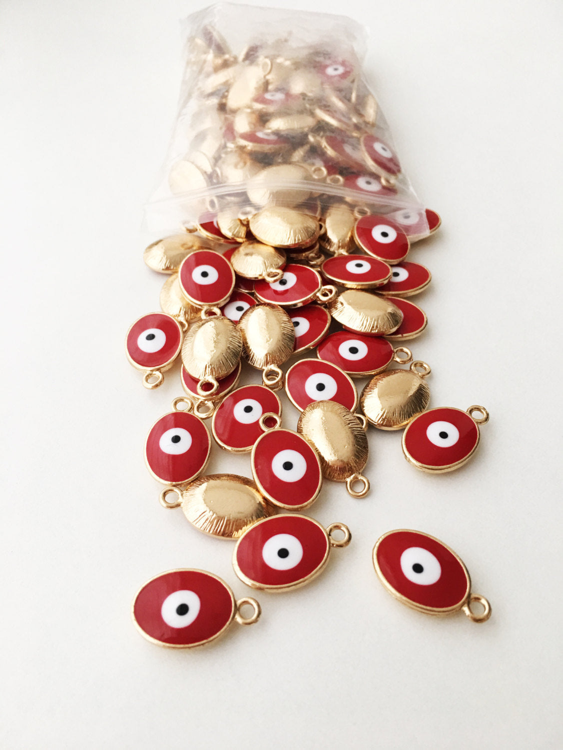 Five gold plated evil eye charms featuring blue Turkish design, available in four colors.