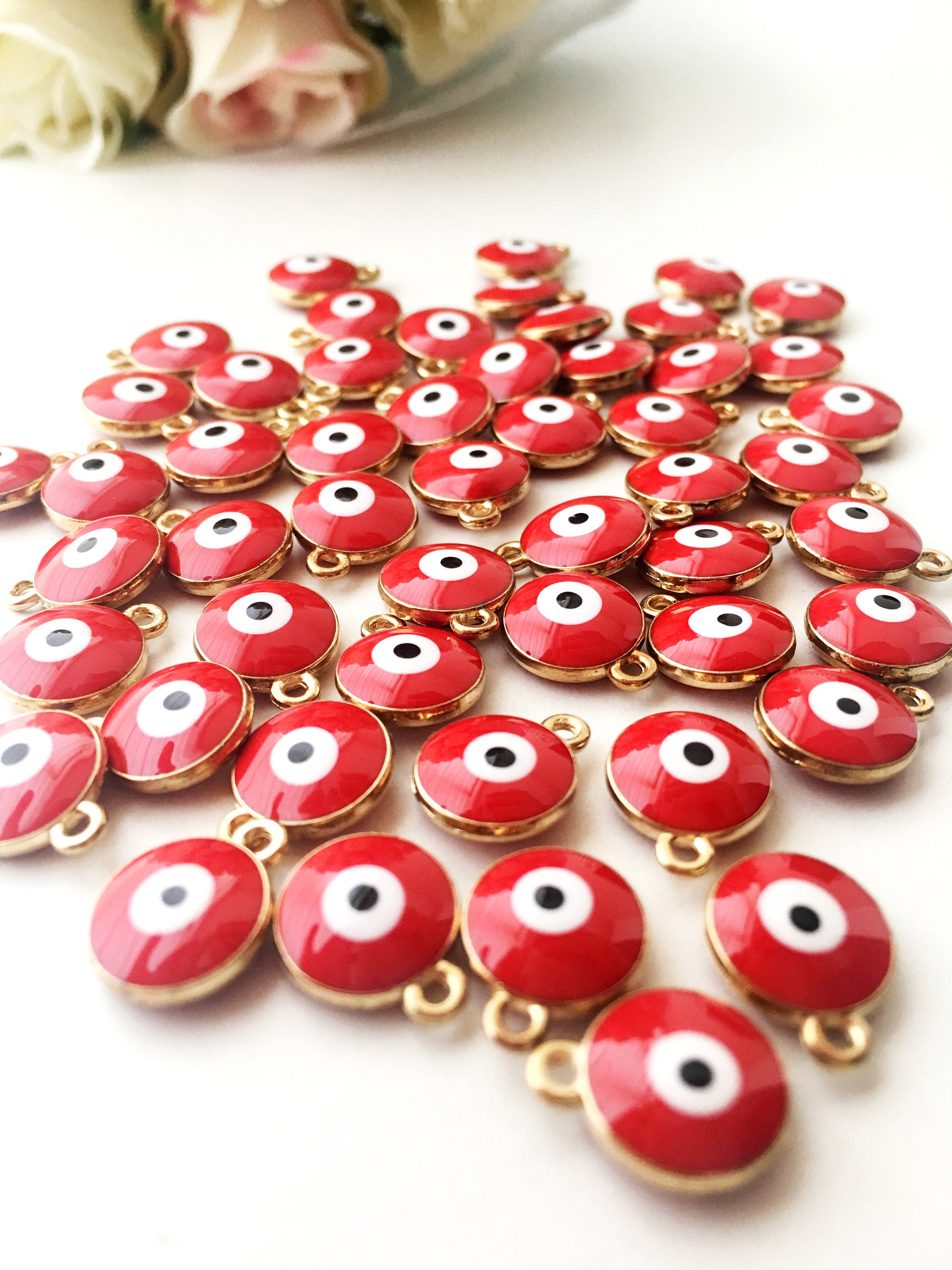 A collection of 5 gold plated evil eye charms featuring red and blue enamel beads, perfect for jewelry making.