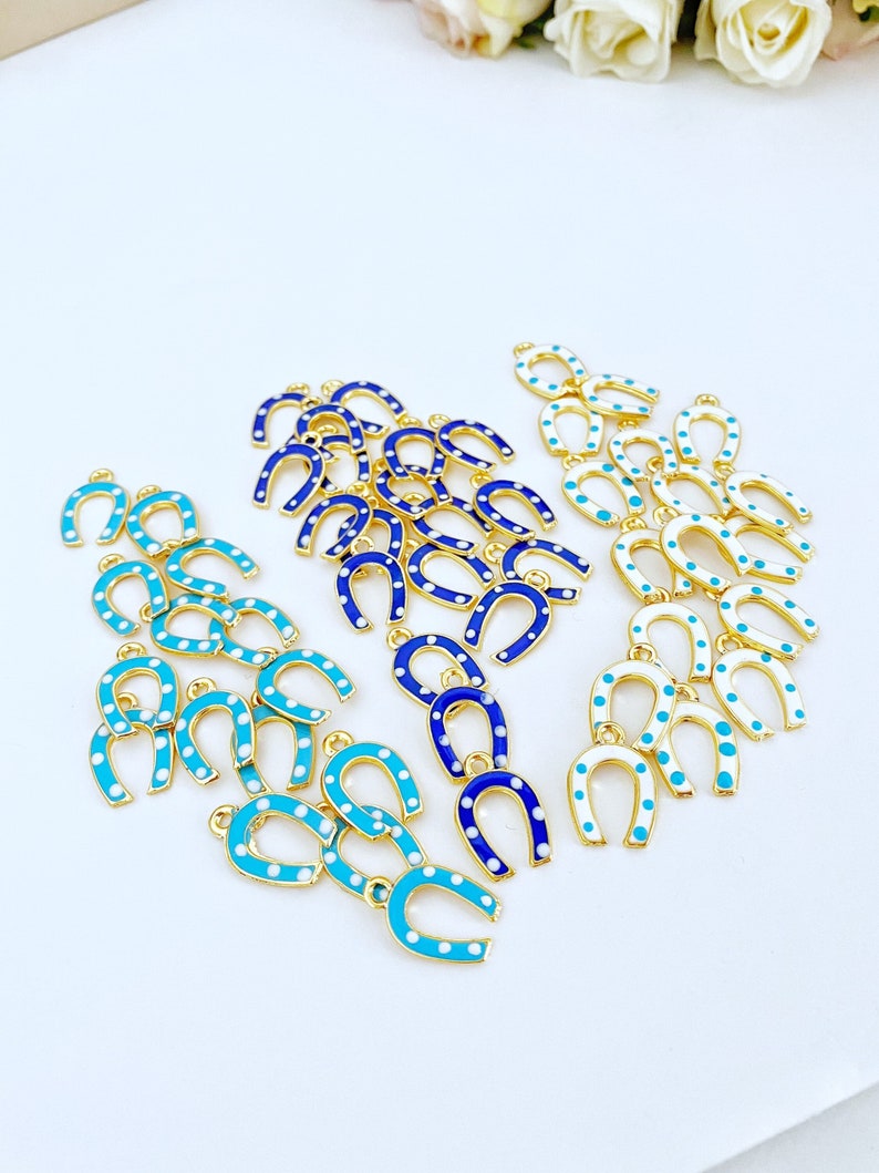 Five mini lucky horseshoe evil eye charms with blue beads, featuring 24K gold plating, perfect for DIY jewelry projects.