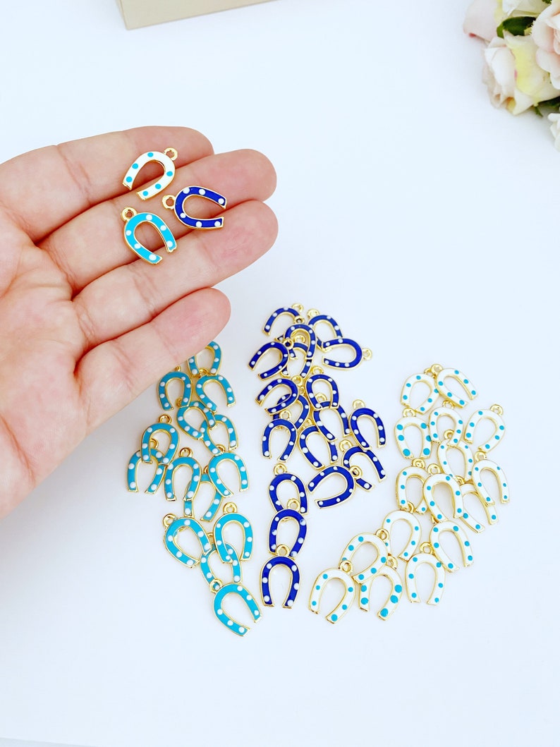 Five mini lucky horseshoe evil eye charms with blue beads, featuring 24K gold plating, perfect for DIY jewelry projects.