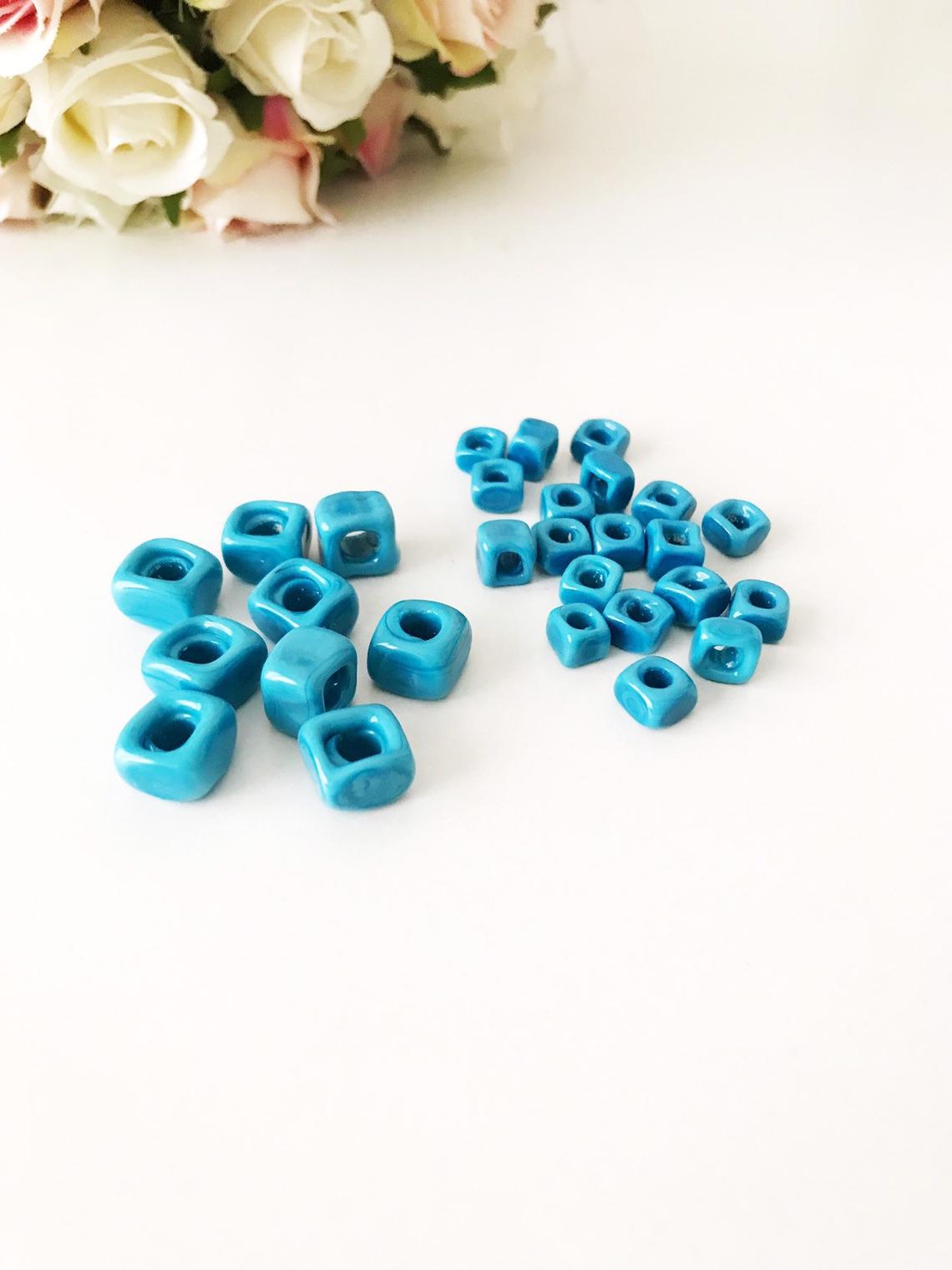 Five colorful Murano cube beads featuring intricate glass evil eye designs, perfect for jewelry making.