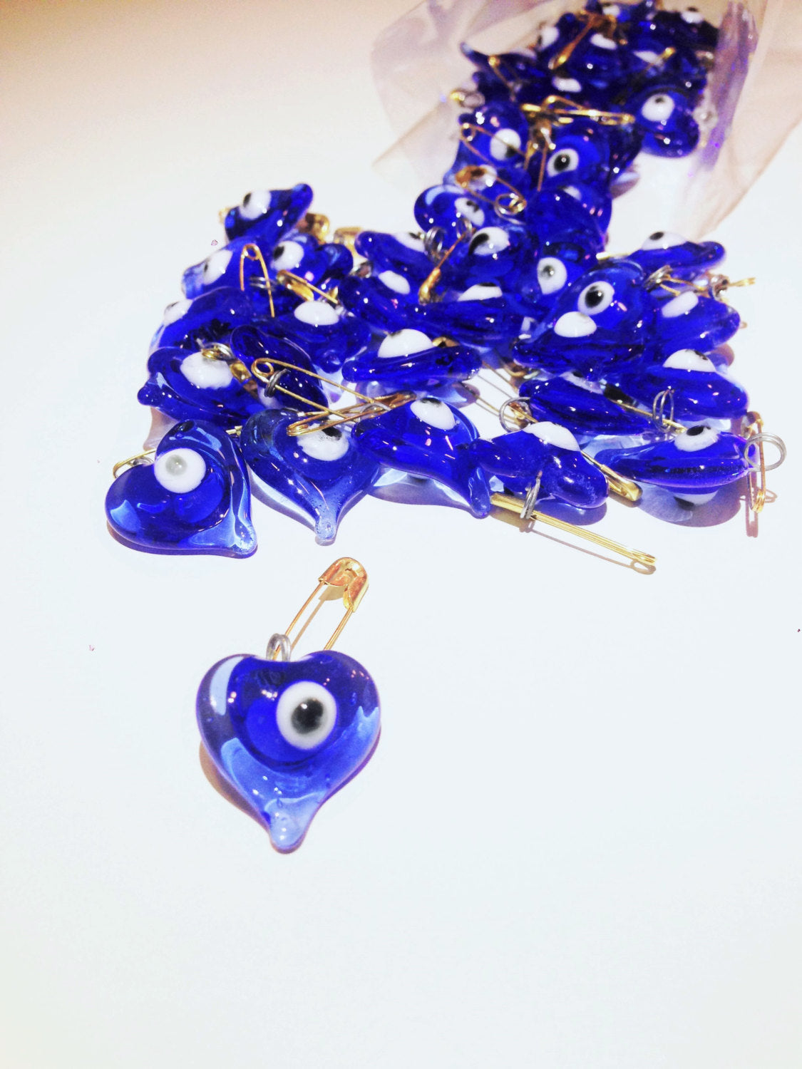 Set of 5 heart-shaped glass evil eye safety pins, perfect for wedding favors and baby showers, showcasing vibrant evil eye beads.