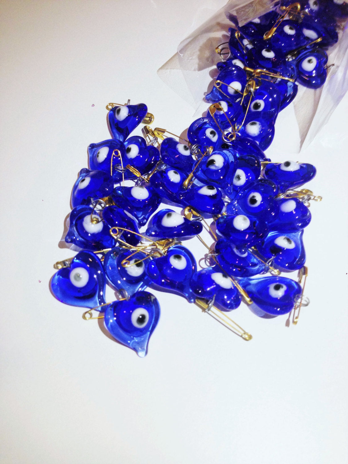 Set of 5 heart-shaped glass evil eye safety pins, perfect for wedding favors and baby showers, showcasing vibrant evil eye beads.