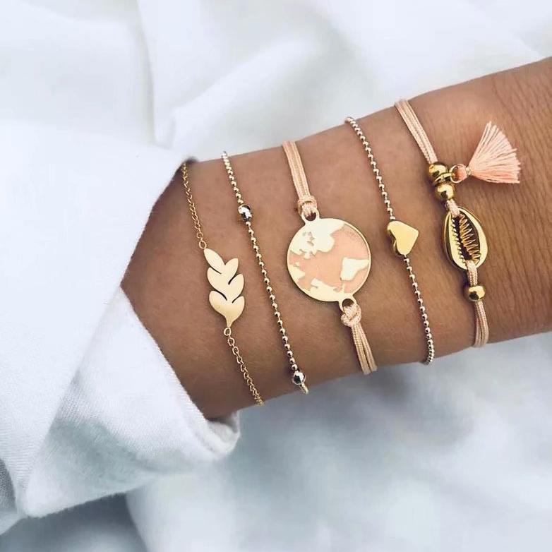 5 Piece Pink Global Tassell Bracelet Set featuring 18K rose gold plating, showcasing elegant tassels and a beautiful pink hue.