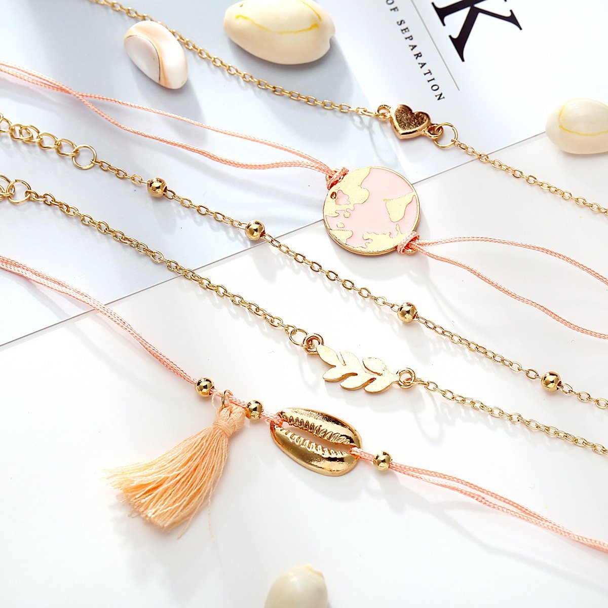 5 Piece Pink Global Tassell Bracelet Set featuring 18K rose gold plating, showcasing elegant tassels and a beautiful pink hue.