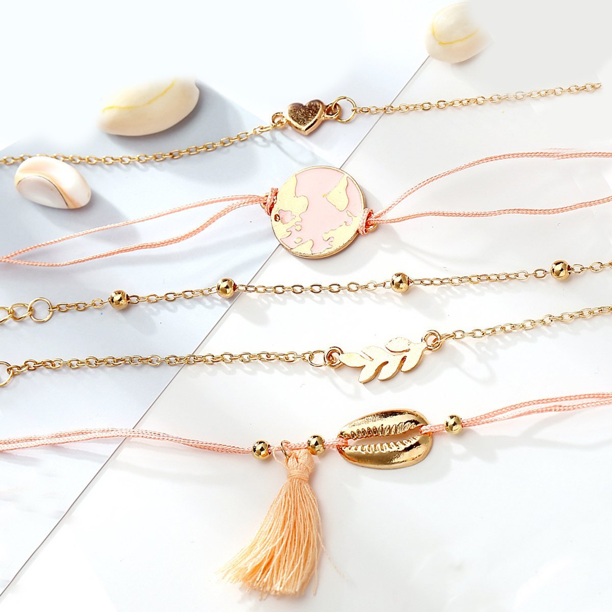 5 Piece Pink Global Tassell Bracelet Set featuring 18K rose gold plating, showcasing elegant tassels and a beautiful pink hue.