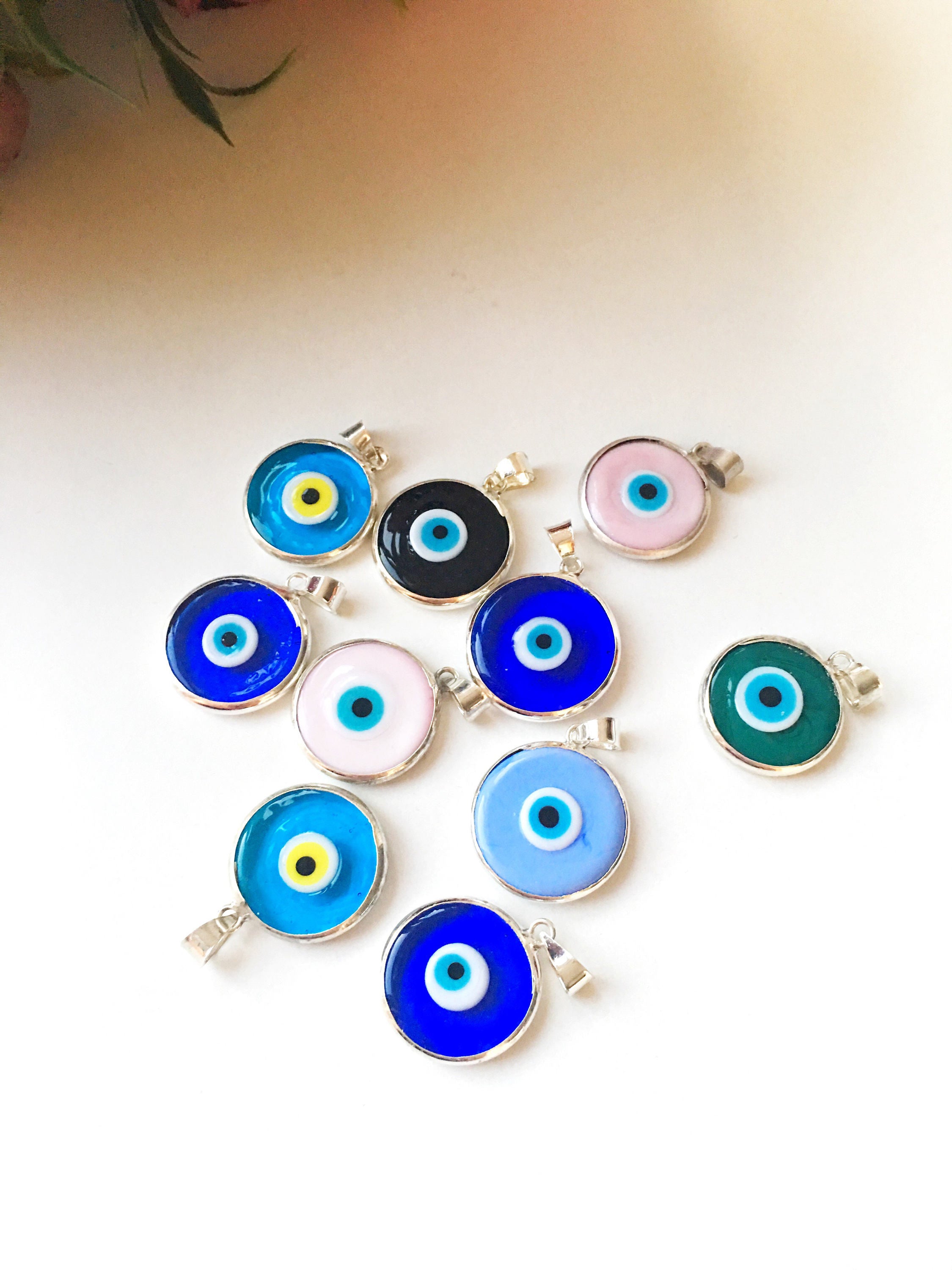 Five silver plated evil eye pendants with 22mm Murano glass charms, showcasing vibrant blue colors and intricate designs.