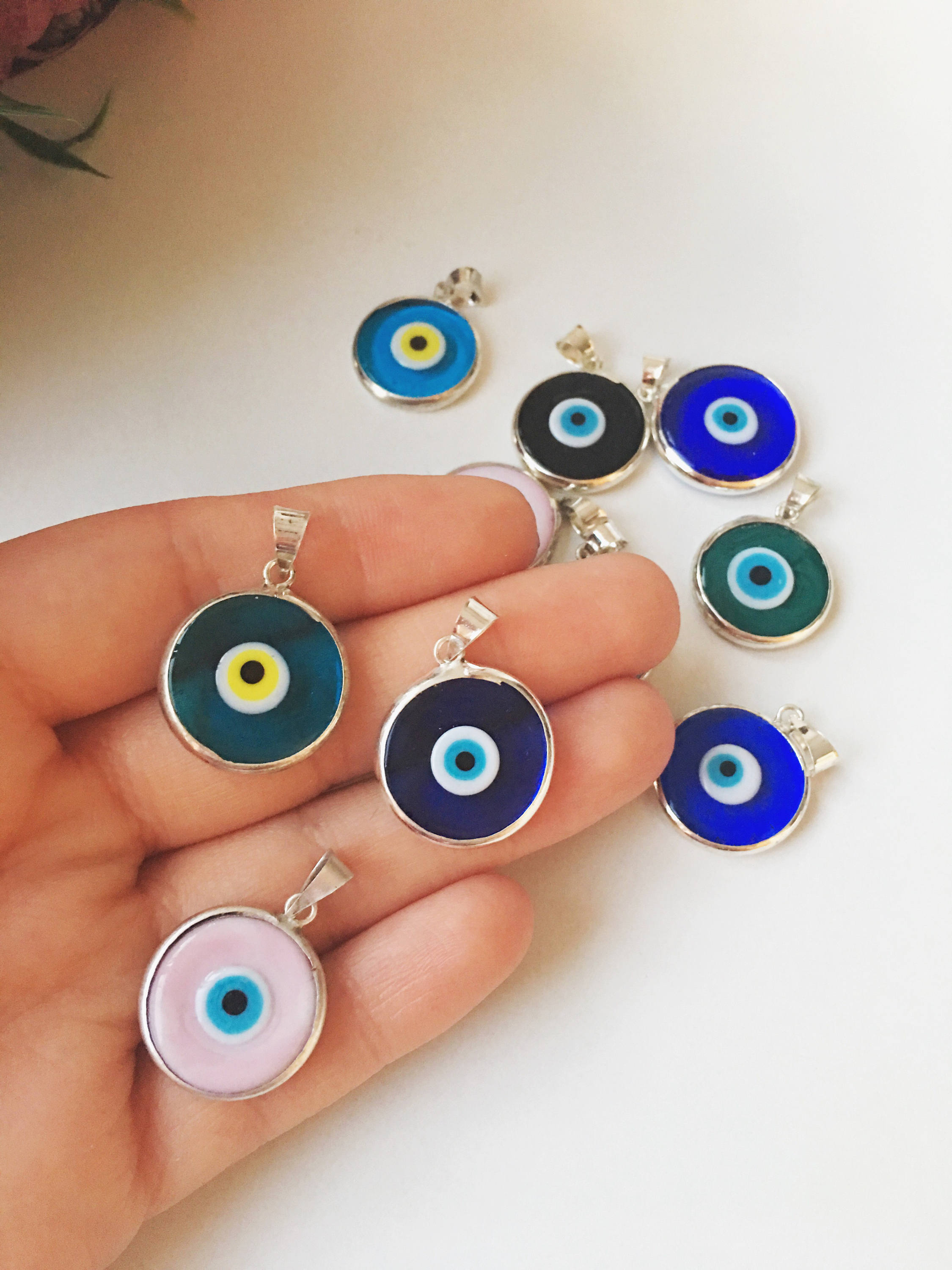 Five silver plated evil eye pendants with 22mm Murano glass charms, showcasing vibrant blue colors and intricate designs.