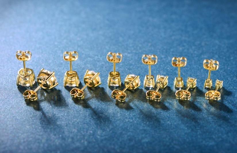 A set of six graduating classic stud earrings in 14K gold plating with white princess cut stones, elegantly displayed.