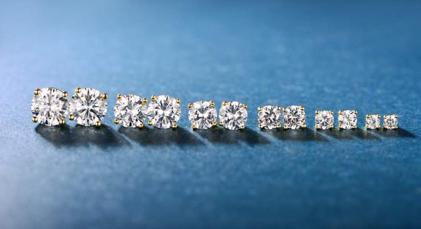 A set of six graduating classic stud earrings in 14K gold plating with white princess cut stones, elegantly displayed.