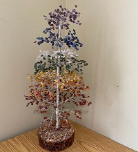 A 20-inch tall 7 Chakra Natural Gemstone Tree with 1000 colorful gemstone chips as leaves, silver wires for branches, and a wooden base.