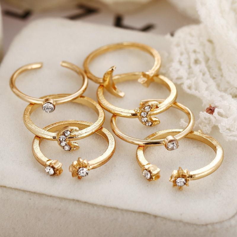 A beautiful 7 piece ring set featuring moon and stars designs, adorned with sparkling gemstone crystals, plated in 18K gold.