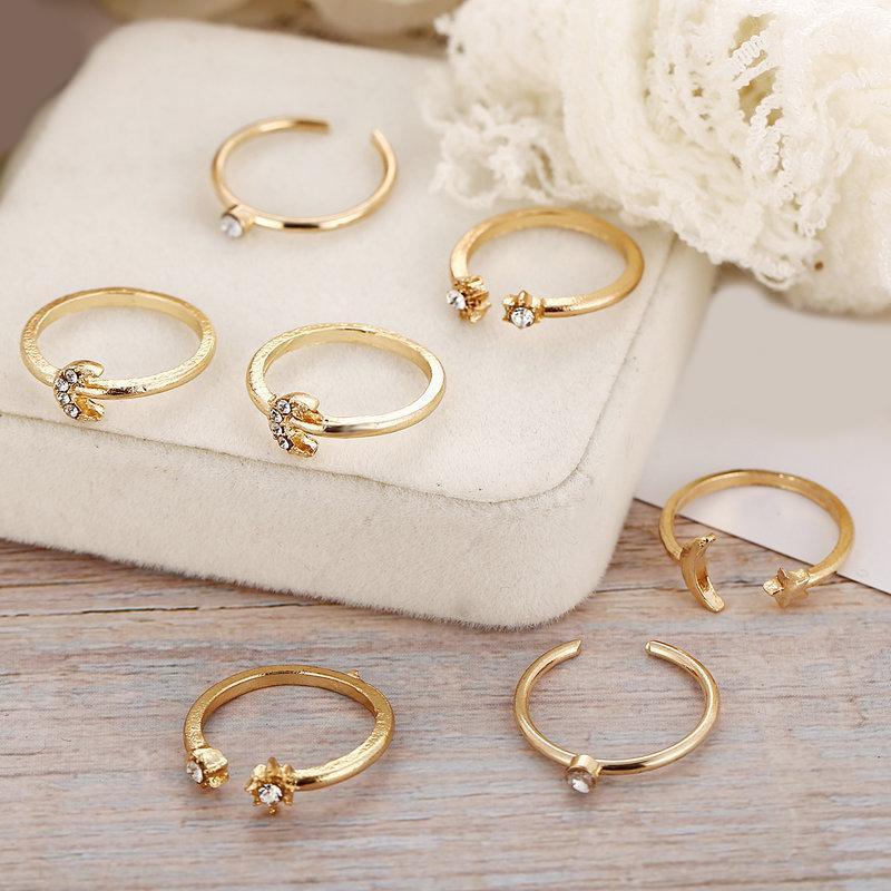 A beautiful 7 piece ring set featuring moon and stars designs, adorned with sparkling gemstone crystals, plated in 18K gold.