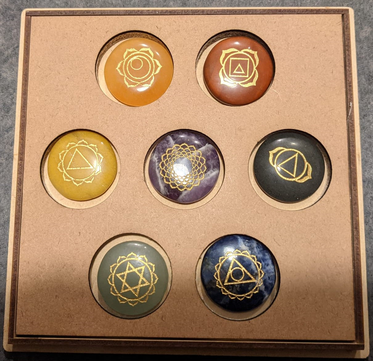 7 Stone Chakra Set Palm Stones with engraved symbols, beautifully polished and presented in a box, ideal for meditation and healing.