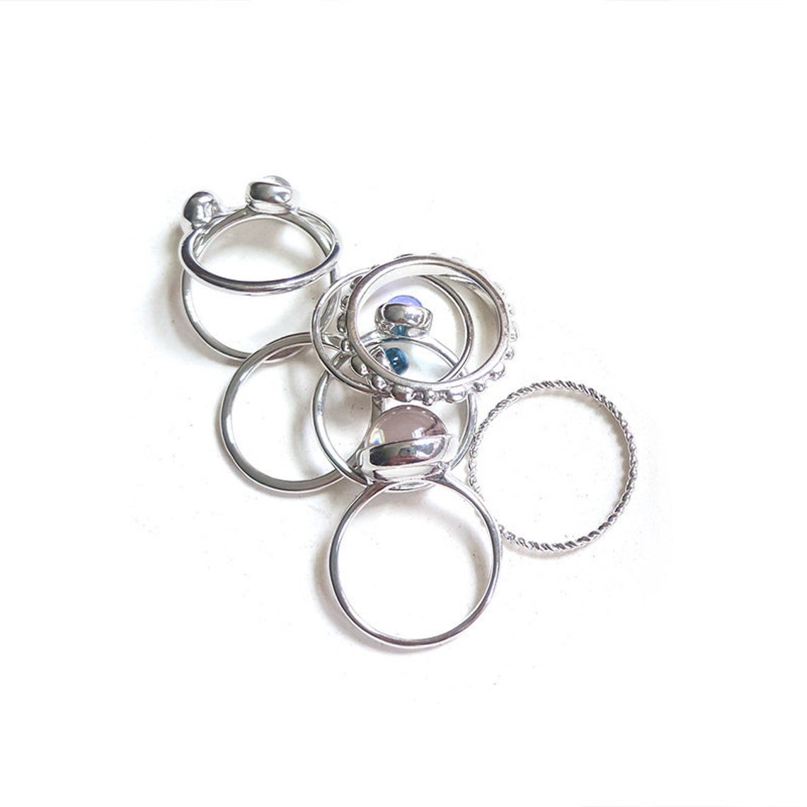 A vibrant set of 8 metallic boho rings in silver and gold, showcasing intricate designs and colorful stones, perfect for stacking.