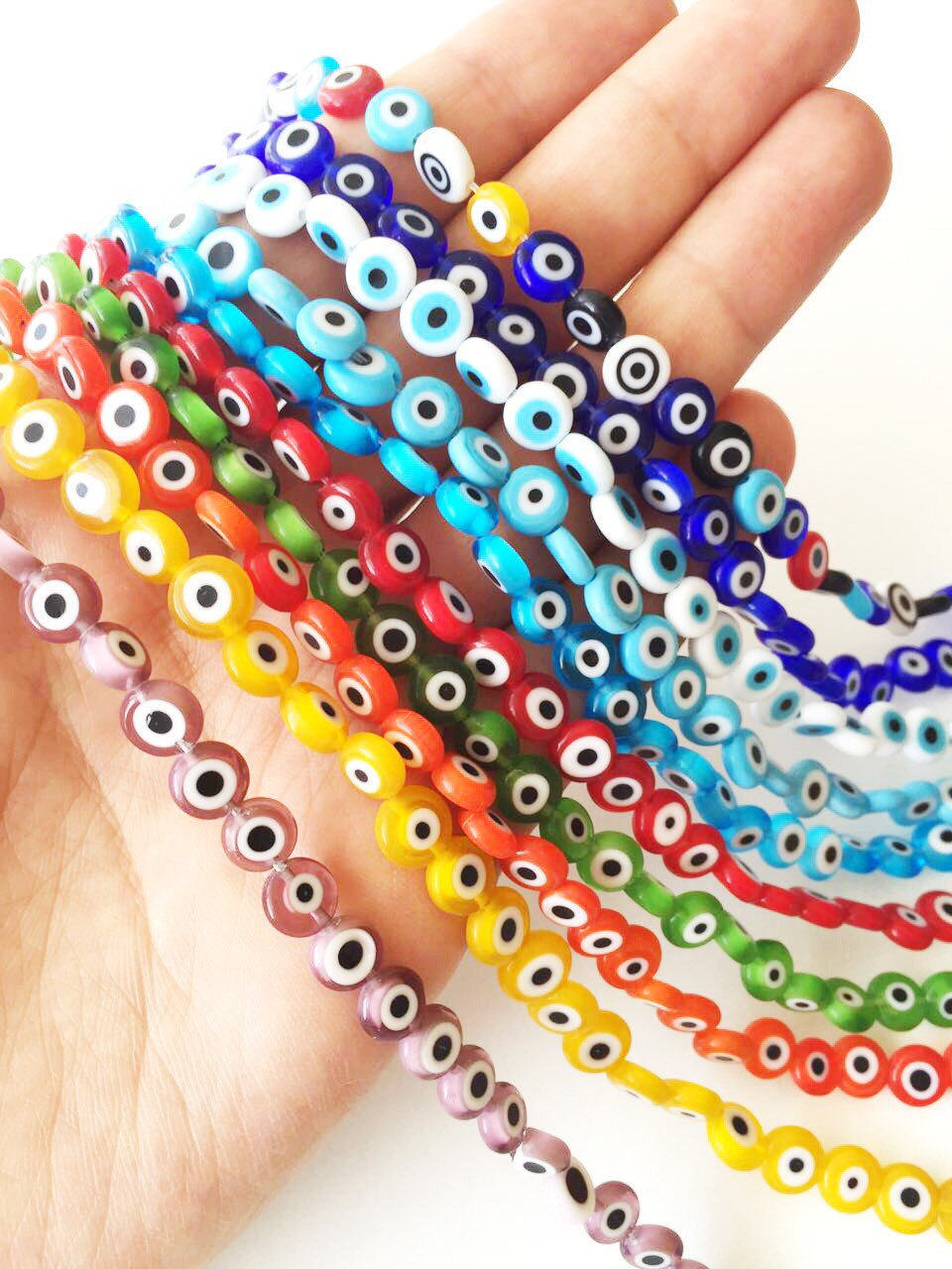 A collection of 40 handmade 8mm Turkish evil eye glass beads in various colors, showcasing their unique designs and protective symbolism.