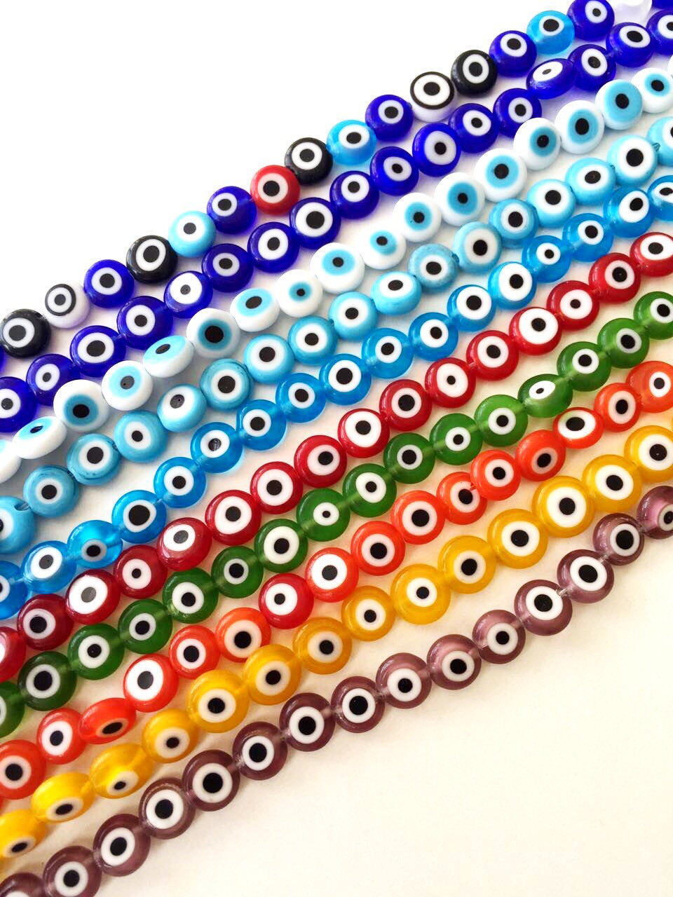 A collection of 40 handmade 8mm Turkish evil eye glass beads in various colors, showcasing their unique designs and protective symbolism.