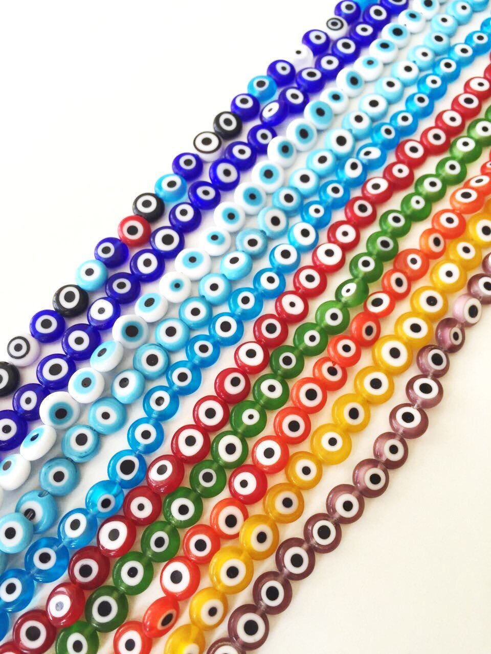 A collection of 40 handmade 8mm Turkish evil eye glass beads in various colors, showcasing their unique designs and protective symbolism.